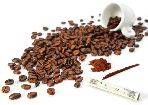 Kaffeekörner, eine Tasse und verdrehte Papierwährung — Stockfoto