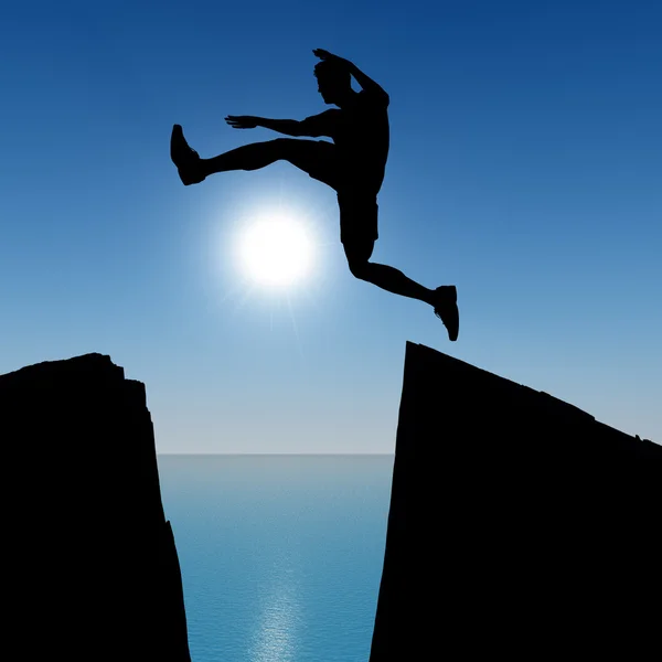 Silhouette of the jumping man from a rock — Stock Photo, Image