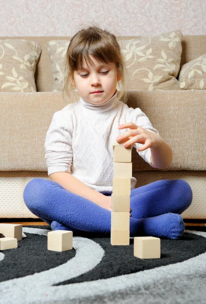 The little girl plays wooden toy cubes — Stock Photo, Image