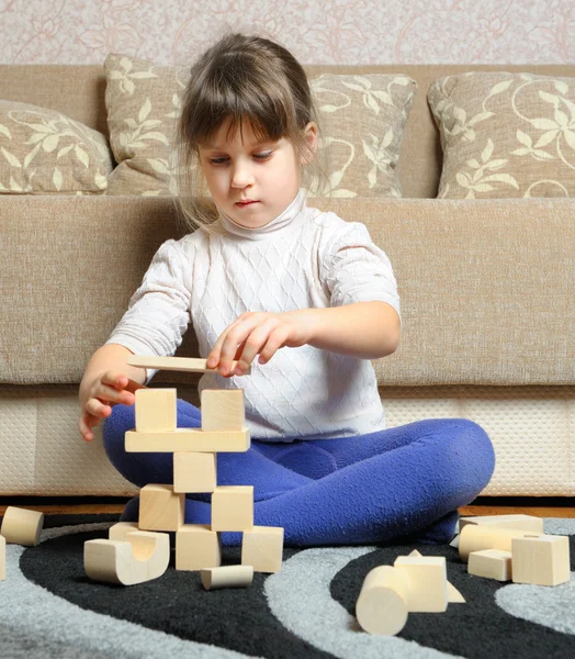 La niña juega cubos de juguete de madera — Foto de Stock