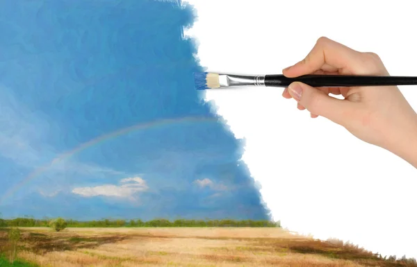 The hand with a brush draws a landscape — Stock Photo, Image