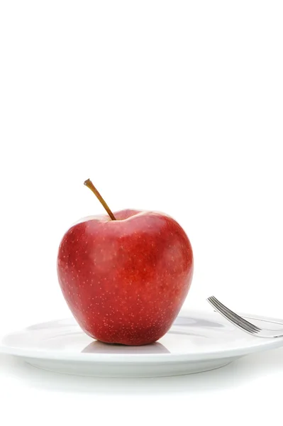 Красное яблоко на тарелке — стоковое фото
