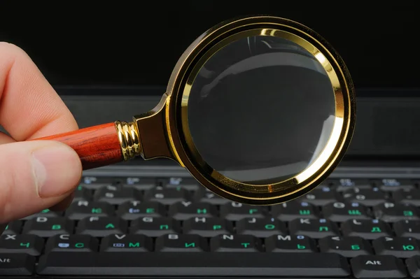 Magnifying glass and a laptop — Stock Photo, Image