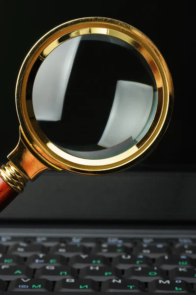 Magnifying glass and a laptop — Stock Photo, Image