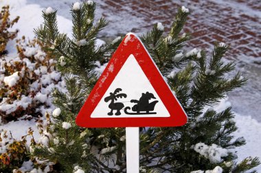 Road sign with Santa Claus on sledges and reindeer in winter clipart