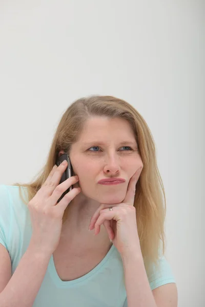 Скептическая женщина на мобильном телефоне — стоковое фото