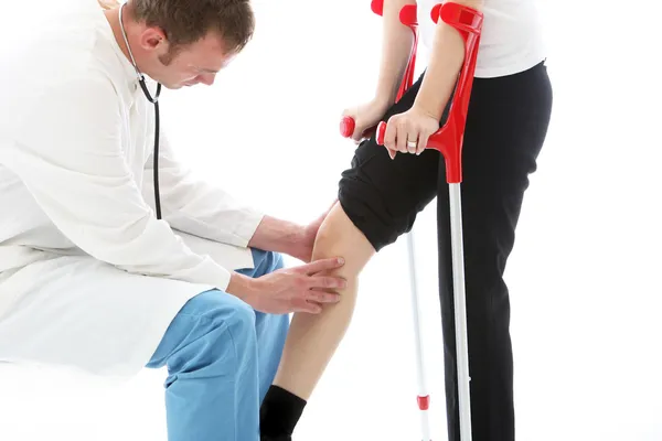 Ortopedický chirurg zkoumá ženské koleno — Stock fotografie