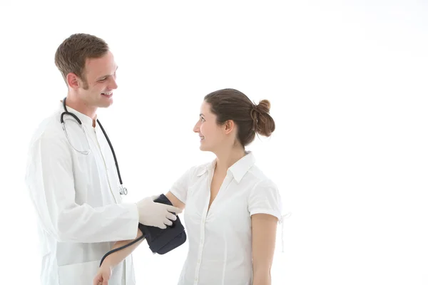 Médecin souriant prenant une lecture de la pression artérielle — Photo