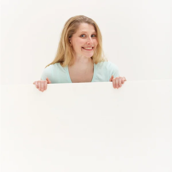 Smiling woman behind blank white board — Stock Photo, Image
