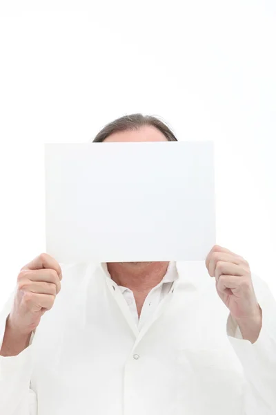 Человек держит чистую бумагу перед лицом — стоковое фото