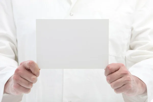 Hombre sosteniendo la tarjeta blanca en blanco delante de sí mismo — Foto de Stock