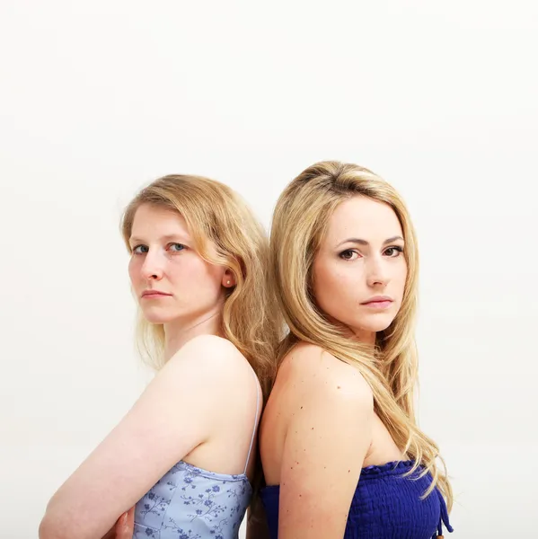 Due donne serie in piedi schiena contro schiena — Foto Stock