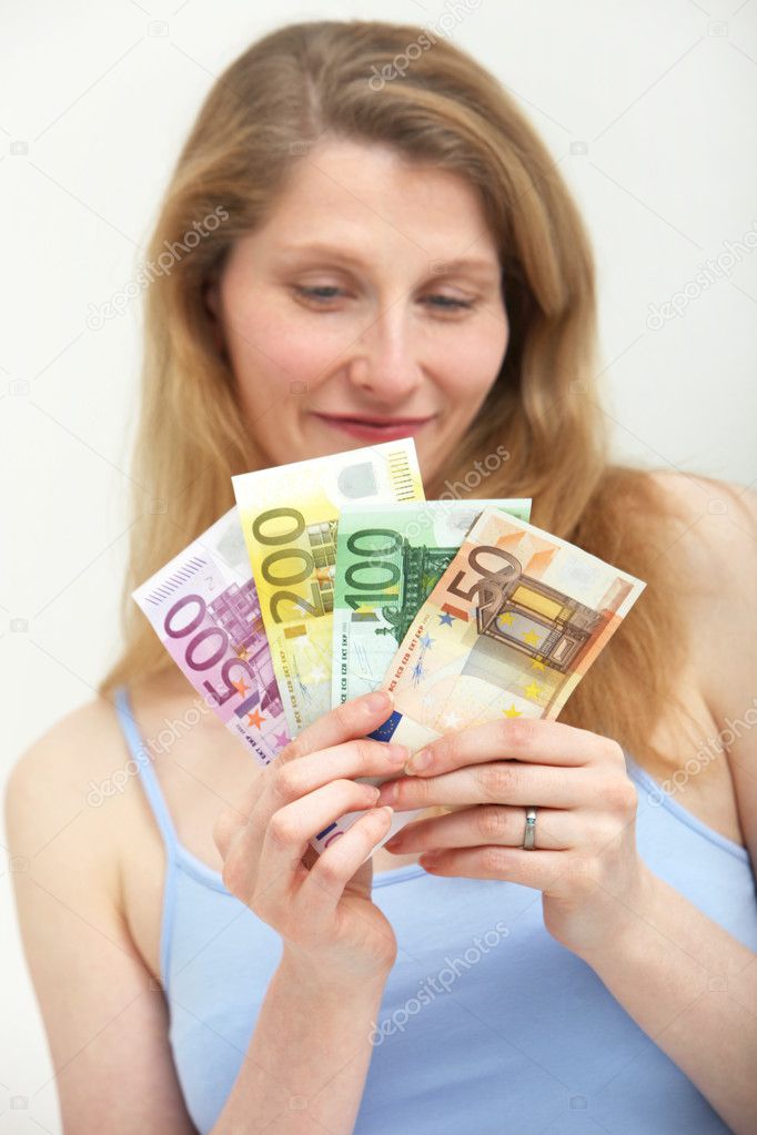 Woman looking ruefully at a handful of money