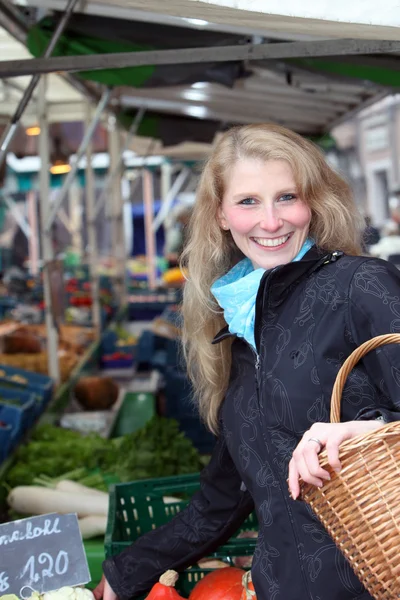 Woman buys vegetables at the market with a basket — Stock Photo, Image