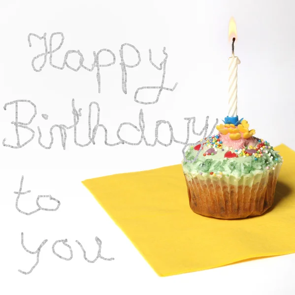 Cupcake com uma vela, e texto feliz aniversário — Fotografia de Stock