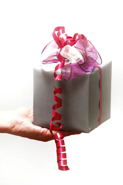 A gift with a bow is held — Stock Photo, Image