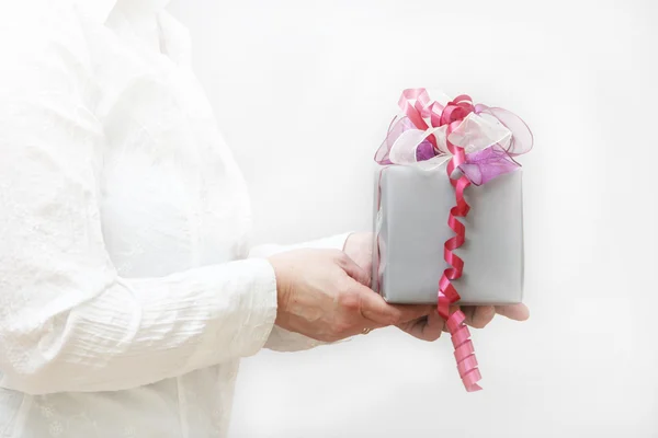 Nice gift with bow is held by women — Stock Photo, Image