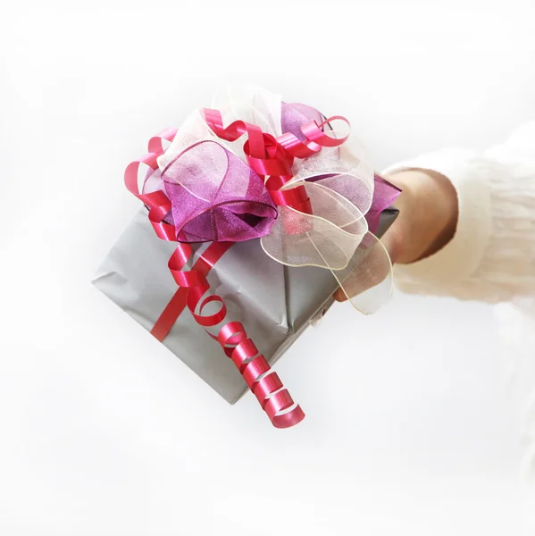 Woman shows nice gift with bow — Stock Photo, Image