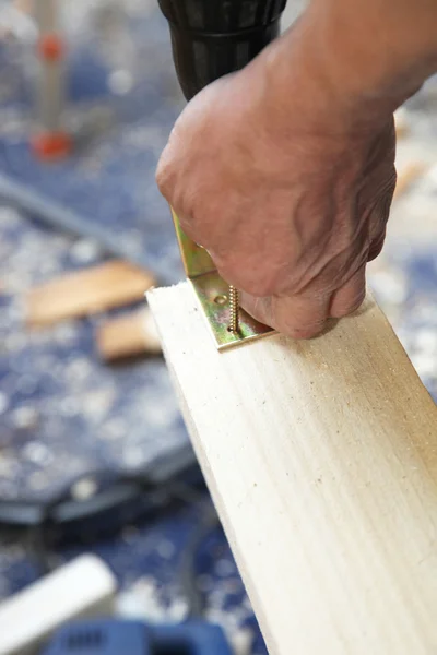 Craftsmen bolted to an angle of wood — Stock Photo, Image