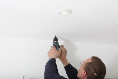Man Drilling White Ceiling clipart