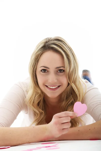 Blondýnka drží růžové srdce — Stock fotografie