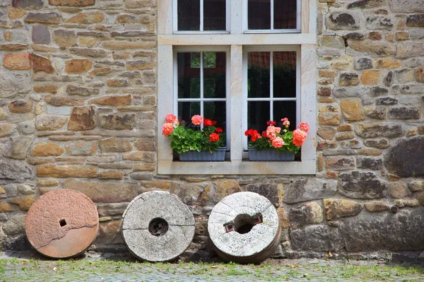 Деревенское окно с гераниумами — стоковое фото