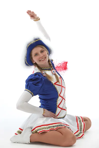 Junge frau i karnelvalsuniform sitzt auf dem boden i tanzpose — Stockfoto