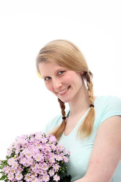 Sarışın kadın çiçek tutan gülümseyerek — Stok fotoğraf