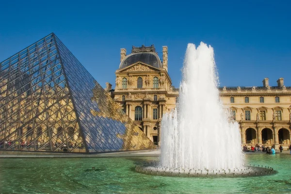 Glass pyramid and fountain in Louvre museum. — Stock Photo, Image
