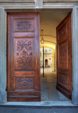 Ornate wooden door. La Morra, Italy. clipart