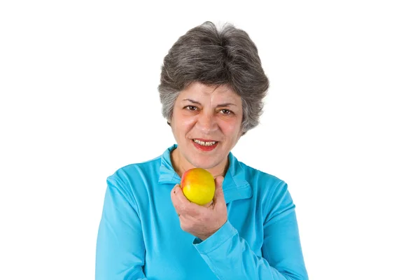 Старшая женщина ест яблоко — стоковое фото