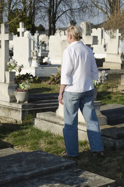 Una donna cammina attraverso un cimitero — Foto Stock