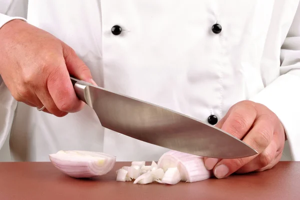 Female chef cut one onion with a kitchen knife — Stock Photo, Image