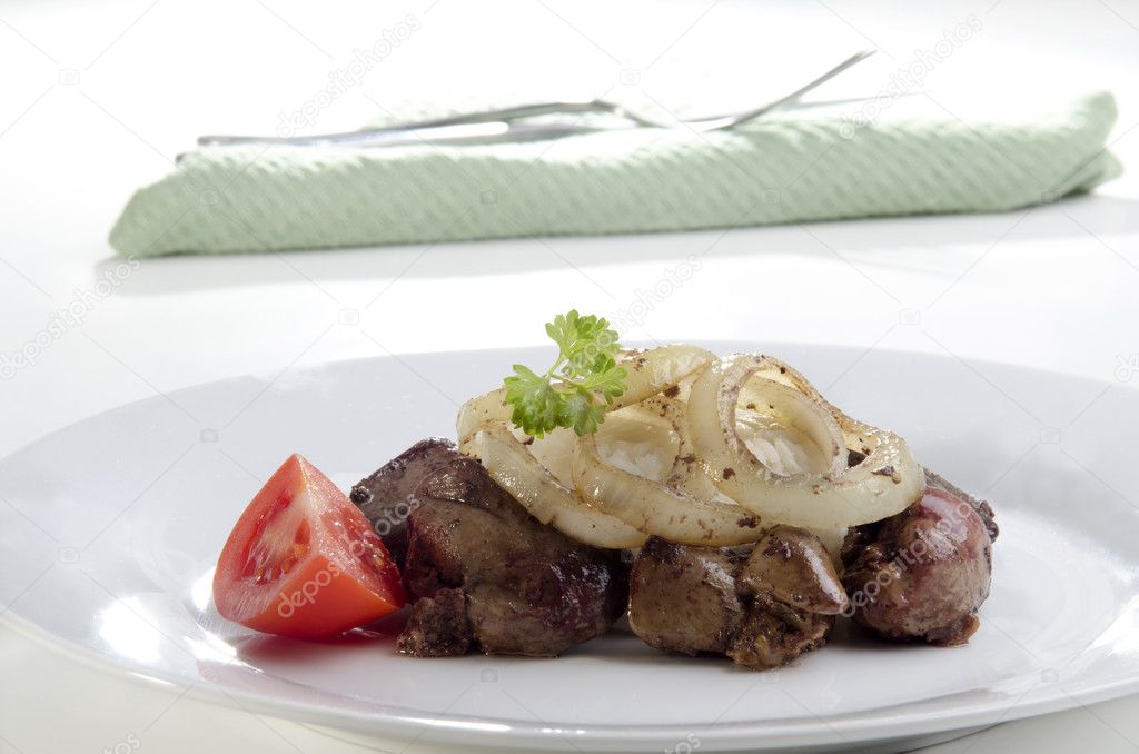 Chicken liver with onion slices on a plate