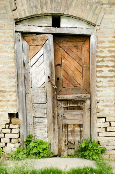 Разрушенная старая деревянная дверь в сарае — стоковое фото