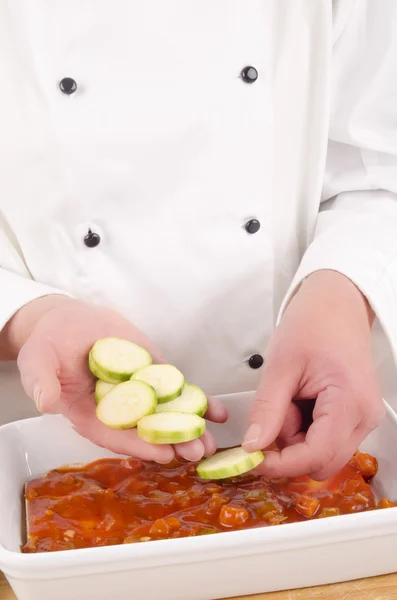 Kvinnliga kock med zucchini skuren i skivor — Stockfoto