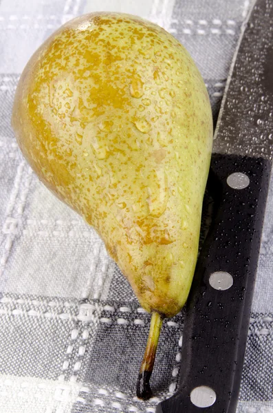 Een natte peer en een keukenmes — Stockfoto