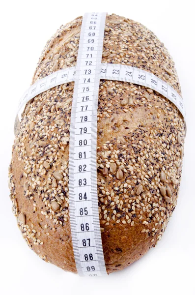 Многозерновой хлеб с измерительной лентой — стоковое фото