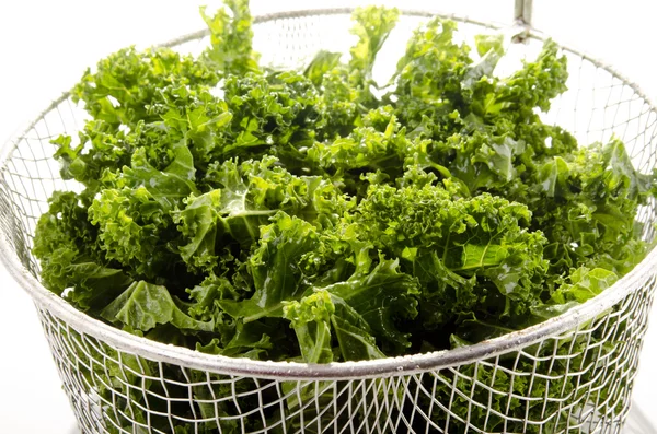 Washed and sliced curly kale in a colander — Stock Photo, Image