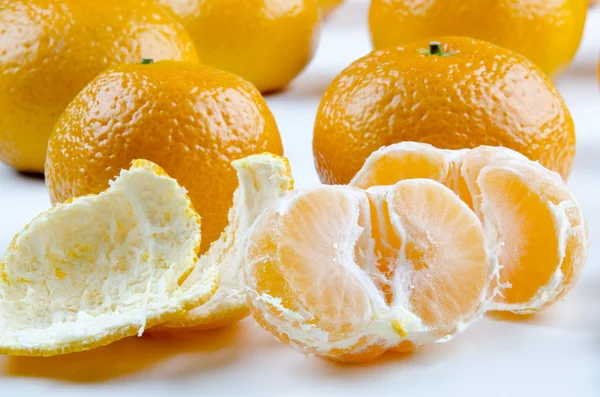Uma mandarina orgânica aberta e algumas em segundo plano — Fotografia de Stock