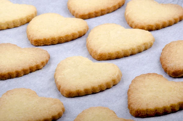Karácsonyi cookie-kat a szív alakú a papír sütés — Stock Fotó
