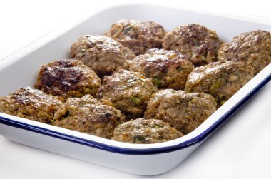 Freshly fried meat balls in a blue and white enamel bowl