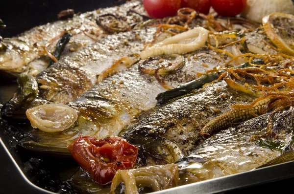 Gegrilde sardines in een pan met tomaten en uien — Stockfoto