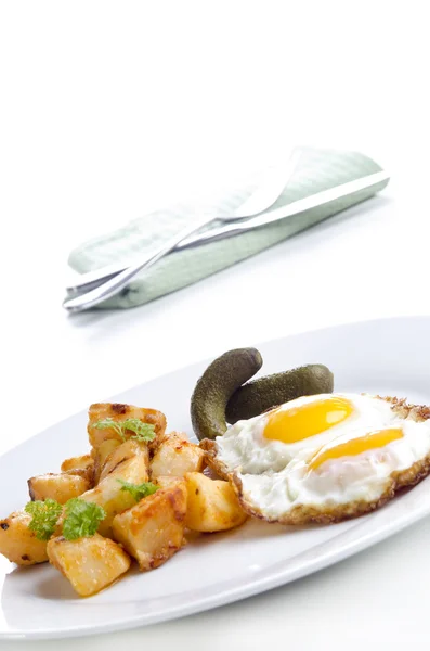 Golden brown fried potatoes with fried eggs — Stock Photo, Image