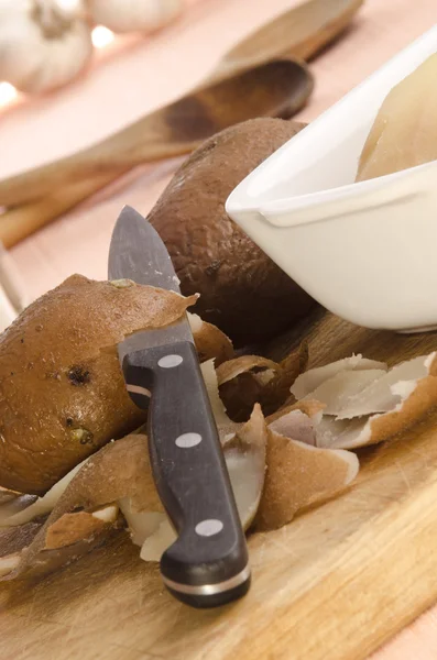 Peeled potato with a kitchen knife — Stock Photo, Image