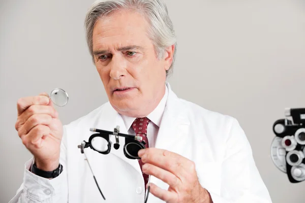 Optometrist τον έλεγχο το φακό του δίκη πλαισίου — Φωτογραφία Αρχείου