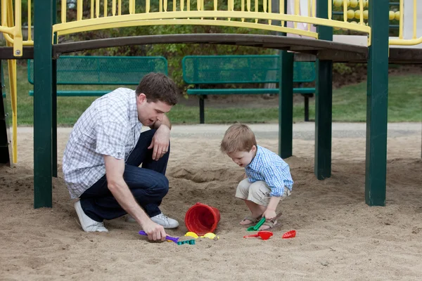 Apa és fia játszik a homok játszótér — Stock Fotó