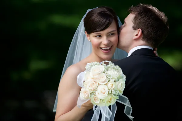 Marié baisers mariée sur oreille — Photo