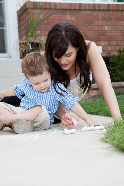 Mother Drawing With Chalk On Sidewalk With Son Stock Image