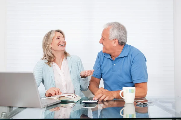 Par på matbord arbetar på bärbar dator — Stockfoto